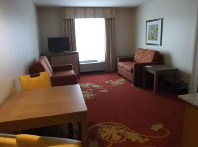 a living room with a couch and a table and chairs at Days Inn & Suites by Wyndham Caldwell in Caldwell