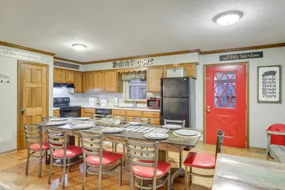 a kitchen with a table and chairs and a red door at 34 Mi to Ark Encounter Kentucky Family Farmhouse in New Richmond