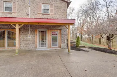 a brick house with a red awning on a driveway at 34 Mi to Ark Encounter Kentucky Family Farmhouse in New Richmond