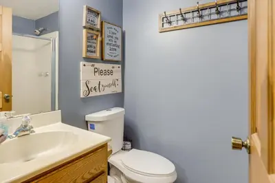 a bathroom with a toilet and a sink and a mirror at 34 Mi to Ark Encounter Kentucky Family Farmhouse in New Richmond