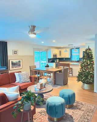 a living room with a couch and a christmas tree at Sunset Cottage Hocking Hills in Rockbridge