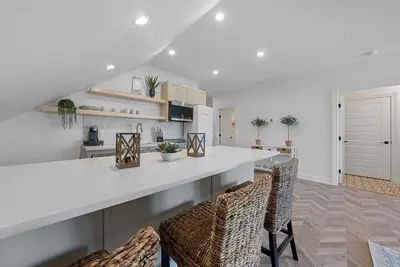 a kitchen with a white counter and chairs at Presidential Suite Sandusky Waterfront Area in Sandusky