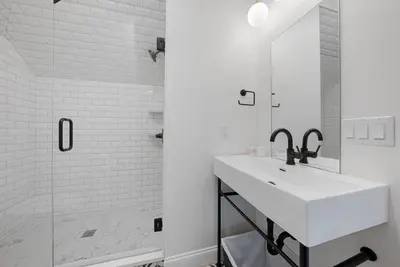 a white bathroom with a sink and a shower at Presidential Suite Sandusky Waterfront Area in Sandusky