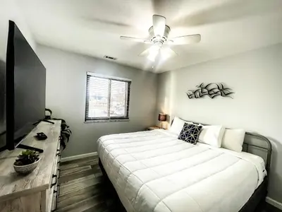 a bedroom with a large bed and a ceiling fan at Modern Condo Central Huron Boat Basin Area in Huron