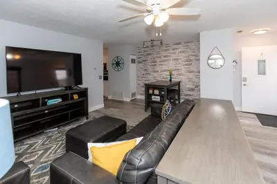a living room with a couch and a flat screen tv at Modern Condo Central Huron Boat Basin Area in Huron