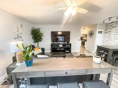 a living room with a table and a ceiling fan at Modern Condo Central Huron Boat Basin Area in Huron