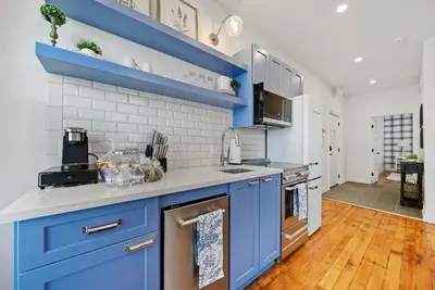 a kitchen with blue cabinets and white walls at Luxury Boutique Downtown Private Unit in Sandusky