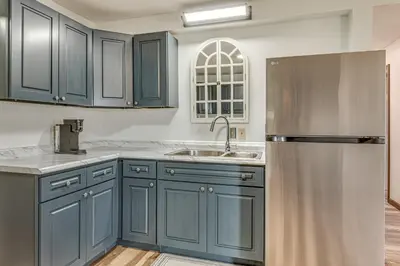 a kitchen with blue cabinets and a stainless steel refrigerator at 17 Mi to Brookville Lake Home with In-Unit Laundry in Connersville