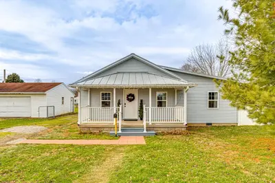 a white house with a porch and a yard at 17 Mi to Brookville Lake Home with In-Unit Laundry in Connersville
