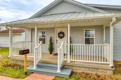 a white house with a porch with a white railing at 17 Mi to Brookville Lake Home with In-Unit Laundry in Connersville