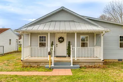 a white house with a porch and a door at 17 Mi to Brookville Lake Home with In-Unit Laundry in Connersville