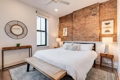 a bedroom with a brick wall and a large bed at Modern Condo in the heart of Over-The-Rhine in Cincinnati