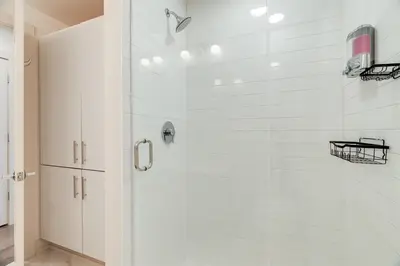 a bathroom with a shower with white tiles at Modern Condo in the heart of Over-The-Rhine in Cincinnati