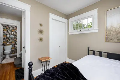 a bedroom with a bed and a window and a toilet at The Craftsman Uptown - Walk to Shops & Eats in Perrysburg
