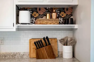 a kitchen counter with wooden utensils on a shelf at The Craftsman Uptown - Walk to Shops & Eats in Perrysburg