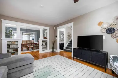 a living room with a couch and a tv at The Craftsman Uptown - Walk to Shops & Eats in Perrysburg