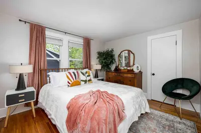a bedroom with a bed and a chair and a window at The Craftsman Uptown - Walk to Shops & Eats in Perrysburg