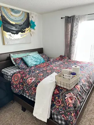 a bedroom with a bed with a blanket and a window at Comfortable King Bedroom within A HOME WITH HOSTS in Columbus