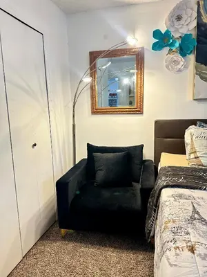 a bedroom with a black chair and a mirror at Comfortable King Bedroom within A HOME WITH HOSTS in Columbus