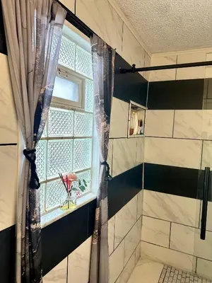 a bathroom with a window and a shower at Comfortable King Bedroom within A HOME WITH HOSTS in Columbus