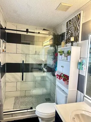 a bathroom with a shower with a toilet and a sink at Comfortable King Bedroom within A HOME WITH HOSTS in Columbus