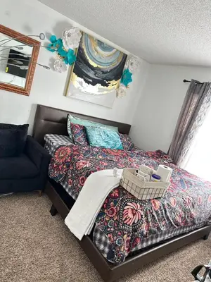 a small bedroom with a bed and a chair at Comfortable King Bedroom within A HOME WITH HOSTS in Columbus