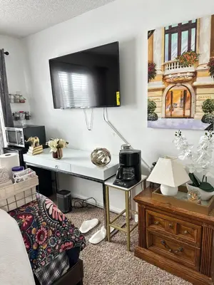 a room with a desk and a tv on a wall at Comfortable King Bedroom within A HOME WITH HOSTS in Columbus