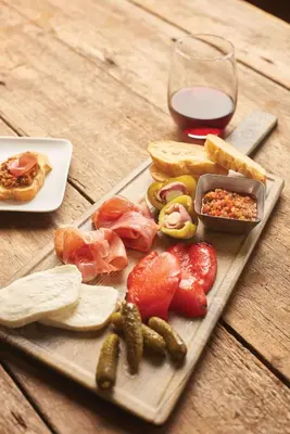 a wooden table with a plate of food and a glass of wine at Hyatt Place Columbus/OSU in Columbus
