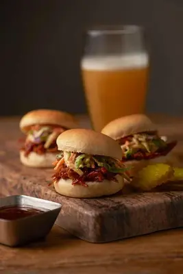 three sandwiches on a cutting board with a glass of beer at Hyatt Place Columbus/OSU in Columbus