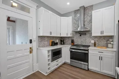 a kitchen with white cabinets and a stove top oven at Minutes to Arena District - Foosball & Game Area in Columbus