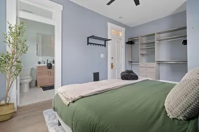 a bedroom with a green bed and a bathroom at Minutes to Arena District - Foosball & Game Area in Columbus