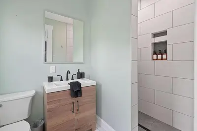 a bathroom with a sink and a toilet and a mirror at Minutes to Arena District - Foosball & Game Area in Columbus