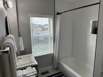 a white bathroom with a tub and a sink at Lovely 2BR Near Downtown Area in Columbus