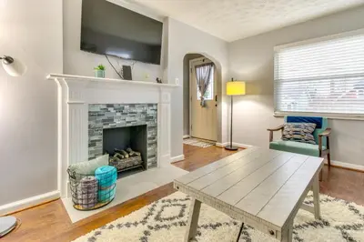 a living room with a fireplace and a table at Walk to Main Street Charming Bellevue Home in Bellevue