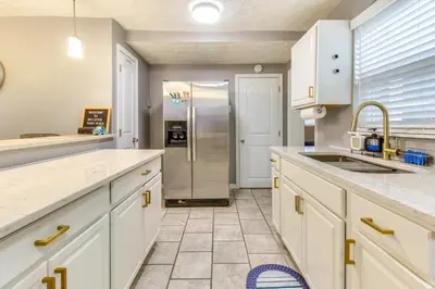 a kitchen with white cabinets and a stainless steel refrigerator at Walk to Main Street Charming Bellevue Home in Bellevue