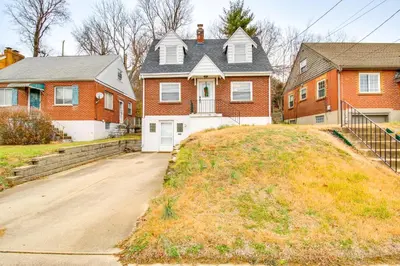 a large red brick house with a driveway at Walk to Main Street Charming Bellevue Home in Bellevue