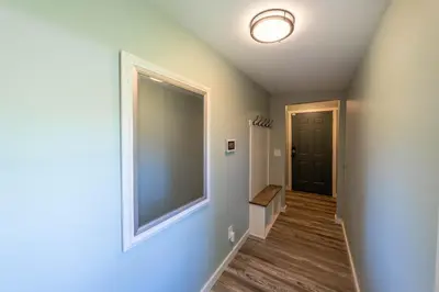 a hallway with a large mirror and a black door at Oberlin Getaway in Oberlin