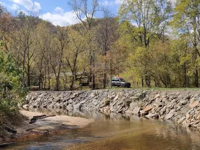 a truck parked on the side of a river at Covered Bridge Hideaway, swimming hole hot tub in Stanton