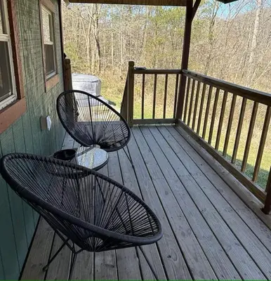 a porch with two chairs and a table on it at Covered Bridge Hideaway, swimming hole hot tub in Stanton