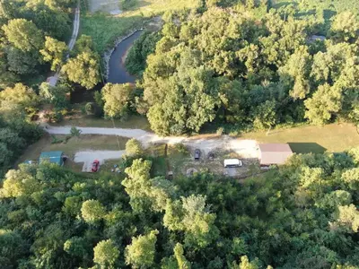 an aerial view of a house in the middle of a forest at Covered Bridge Hideaway, swimming hole hot tub in Stanton
