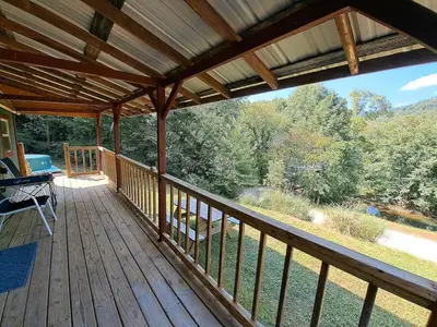 a large wooden deck with a view of the woods at Covered Bridge Hideaway, swimming hole hot tub in Stanton