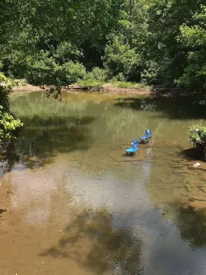 two boats sitting in the middle of a river at Covered Bridge Hideaway, swimming hole hot tub in Stanton