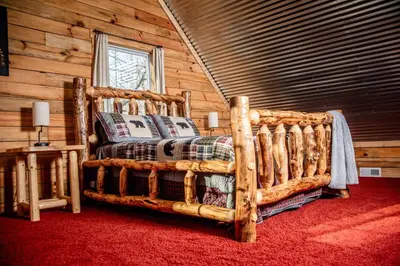 a bedroom with a bed made out of logs at Hocking Hills Cabin, Hot Tub, Private Pond in McArthur