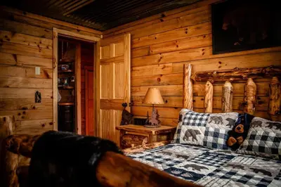 a bedroom with a bed in a log cabin at Hocking Hills Cabin, Hot Tub, Private Pond in McArthur