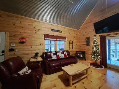 a living room with leather furniture and a christmas tree at Hocking Hills Cabin, Hot Tub, Private Pond in McArthur