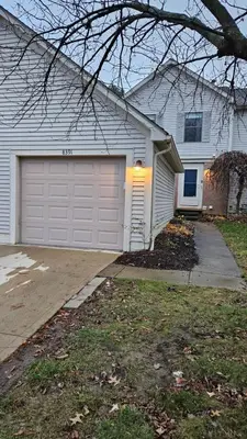 a white house with a garage and a driveway at North Columbus Townhouse - Central, Updated, Fireplace in Columbus