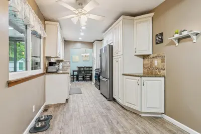 a kitchen with white cabinets and a refrigerator at CVNP Winter Getaway - 5 mins to Boston Mills Ski in Northfield