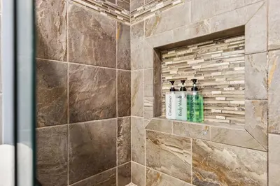 a bathroom with a shower with four bottles of soap at CVNP Winter Getaway - 5 mins to Boston Mills Ski in Northfield