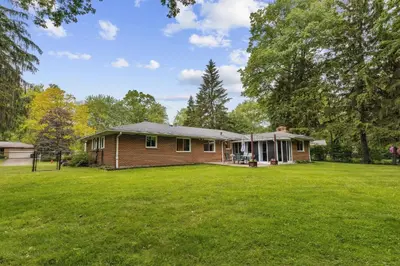 a small house in a field with a yard at CVNP Winter Getaway - 5 mins to Boston Mills Ski in Northfield