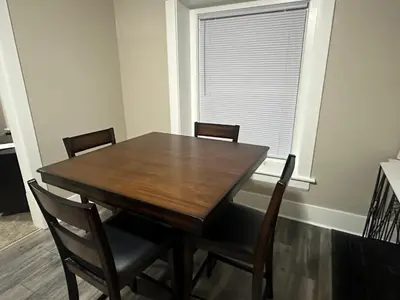 a dining room table with four chairs and a window at The Perazim in Akron